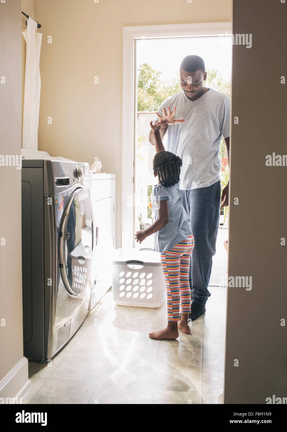 African American padre e figlia facendo servizio lavanderia Foto Stock