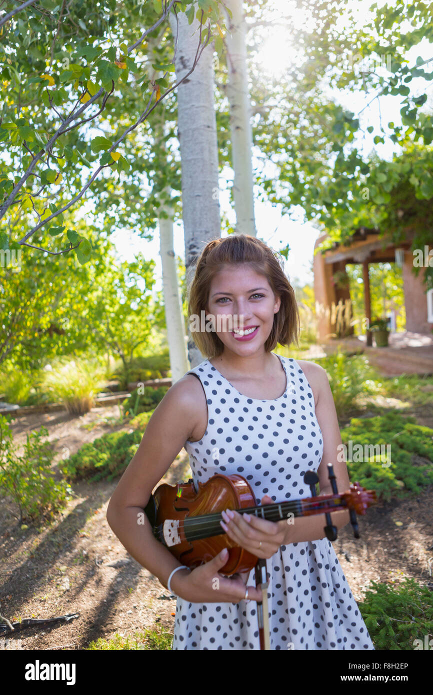 Razza mista musicista holding violino all'aperto Foto Stock