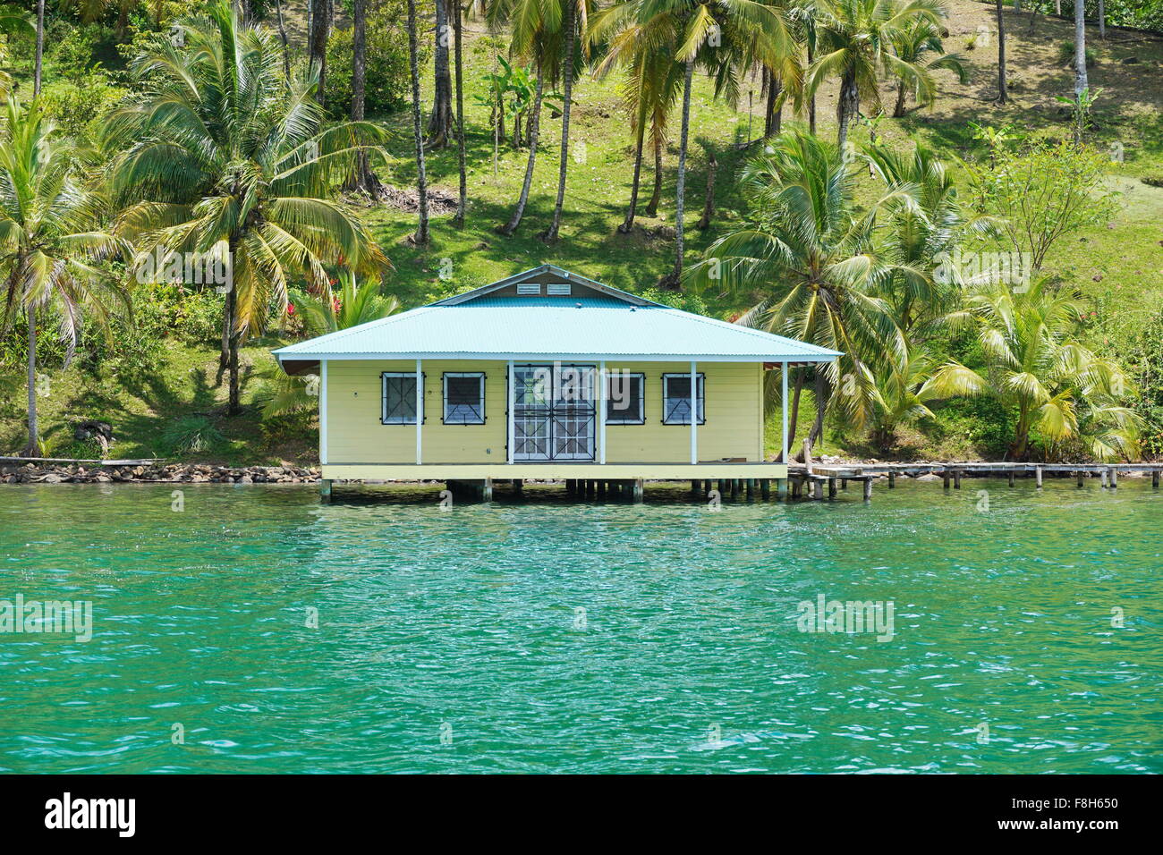 Casa tropicale sull'acqua con palme da cocco sulla riva, visto dal mare dei Caraibi, Panama America Centrale Foto Stock