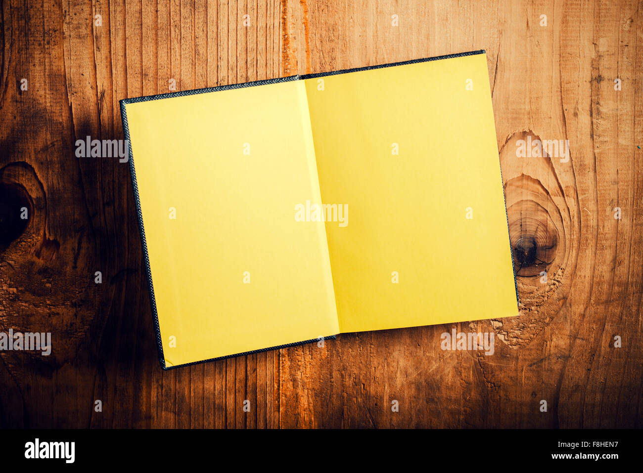 Vista superiore del notebook aperto con pagine vuote sulla vecchia scrivania in legno, dai toni rétro immagine come spazio di copia Foto Stock