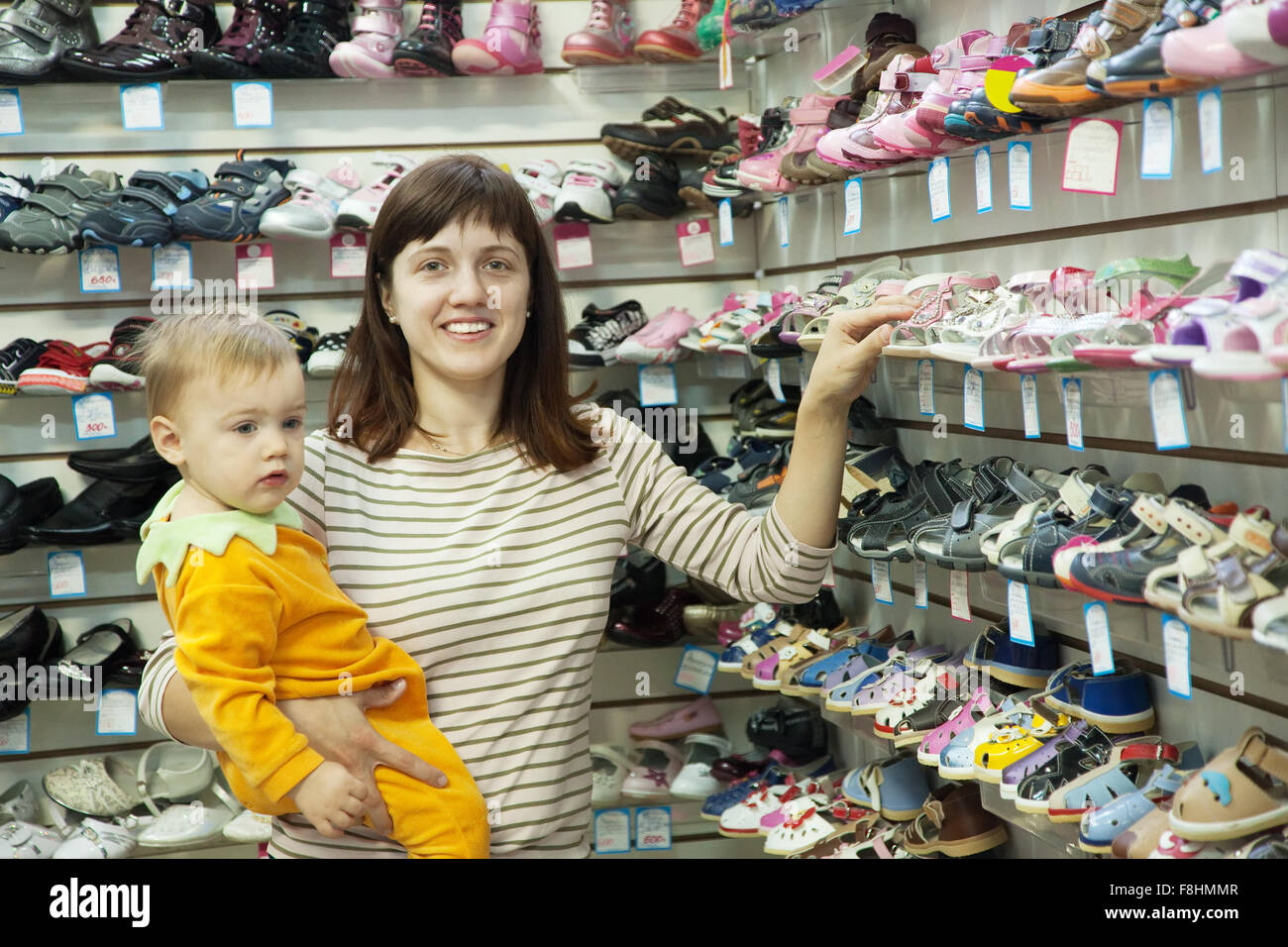 Felice madre con bambino sceglie scarpe per bambini al negozio di moda Foto  stock - Alamy