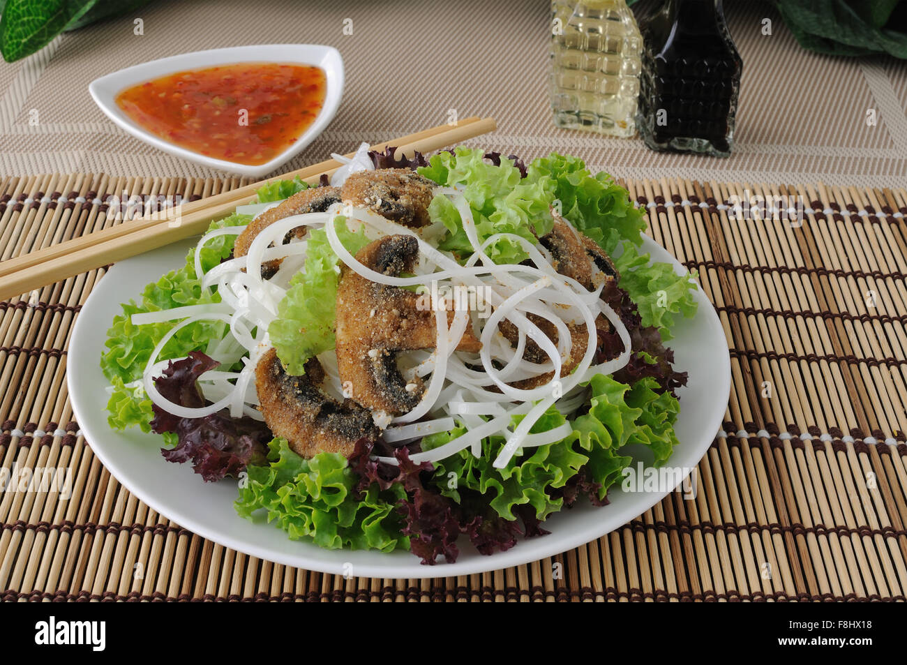 Insalata di riso tagliatelle in foglie di lattuga con funghi impanati Foto Stock