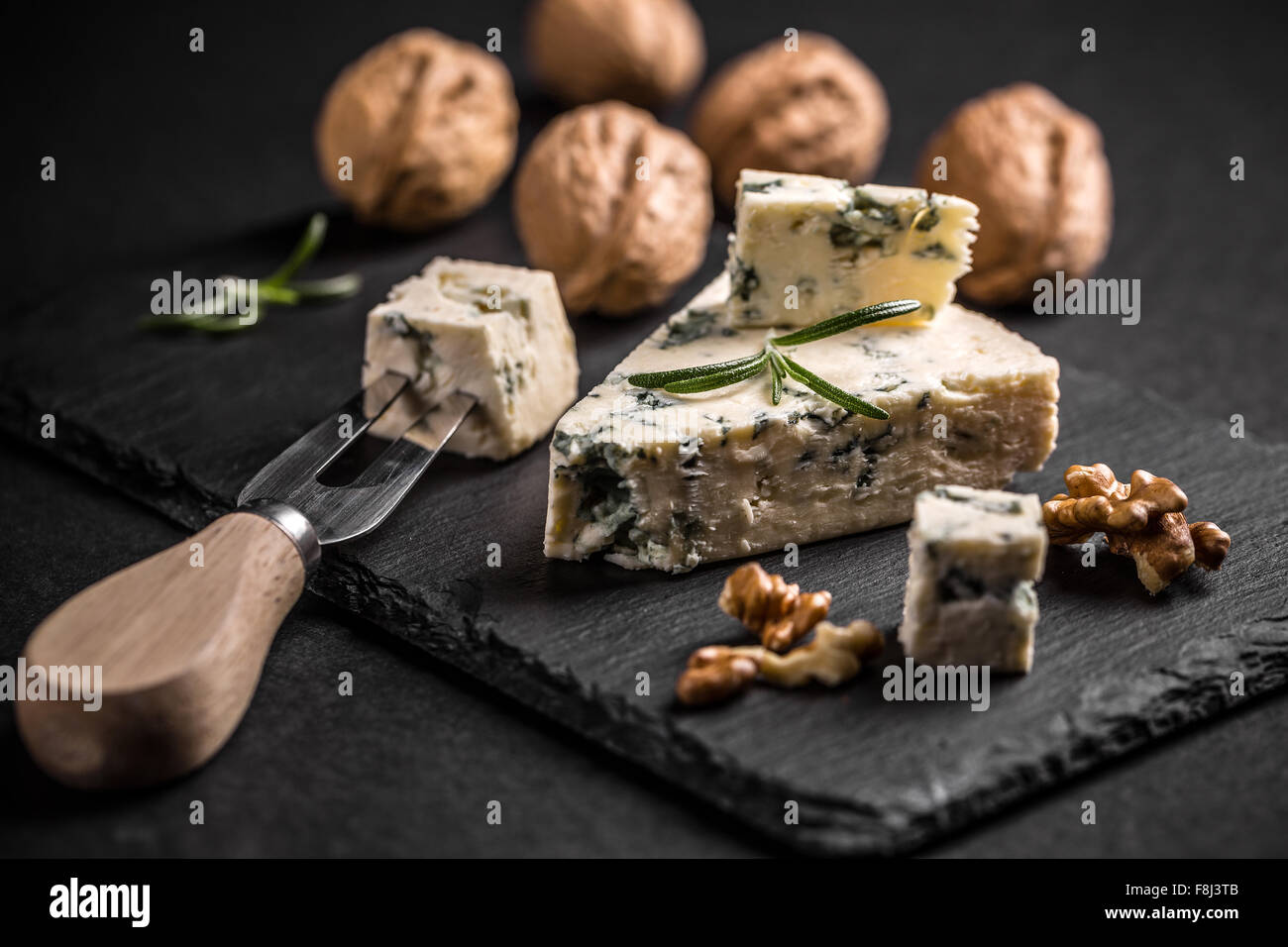 Formaggio blu con il dado su nero ardesia Foto Stock