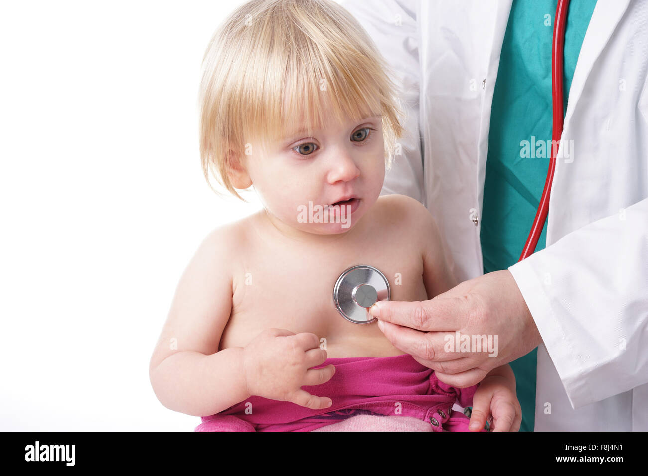 Il medico esamina il toddler bambino e ascolto di cuore e polmoni con stetoscopio. La bambina è felice, isolato su bianco Foto Stock