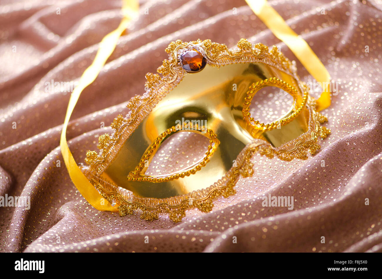 Maschera d'oro su sfondo satinato Foto Stock