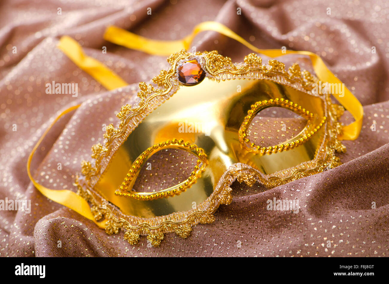 Maschera d'oro su sfondo satinato Foto Stock