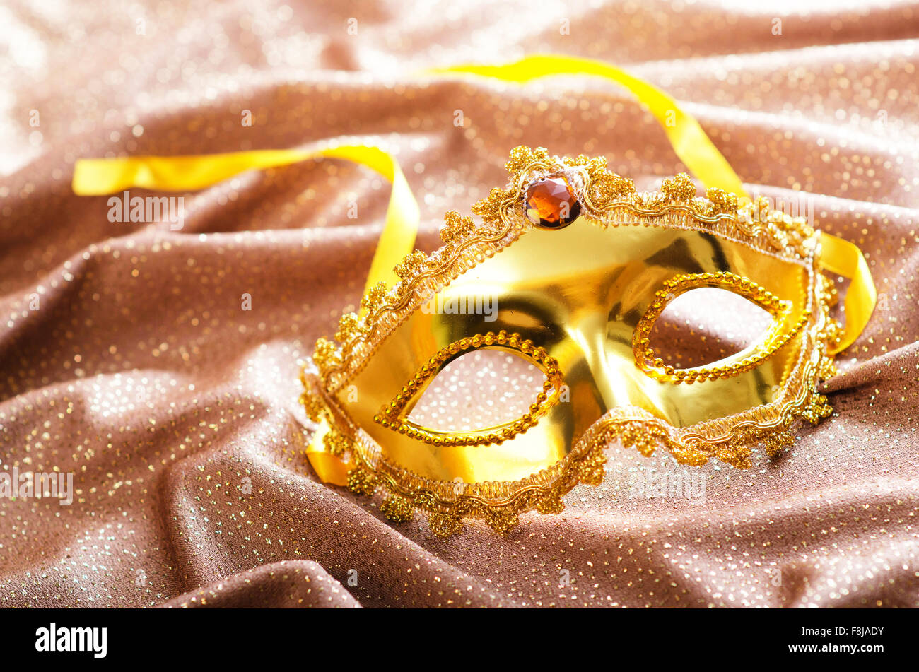 Maschera d'oro su sfondo satinato Foto Stock