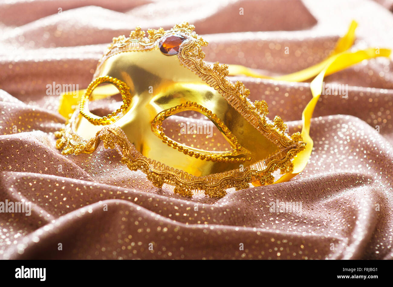 Maschera d'oro su sfondo satinato Foto Stock