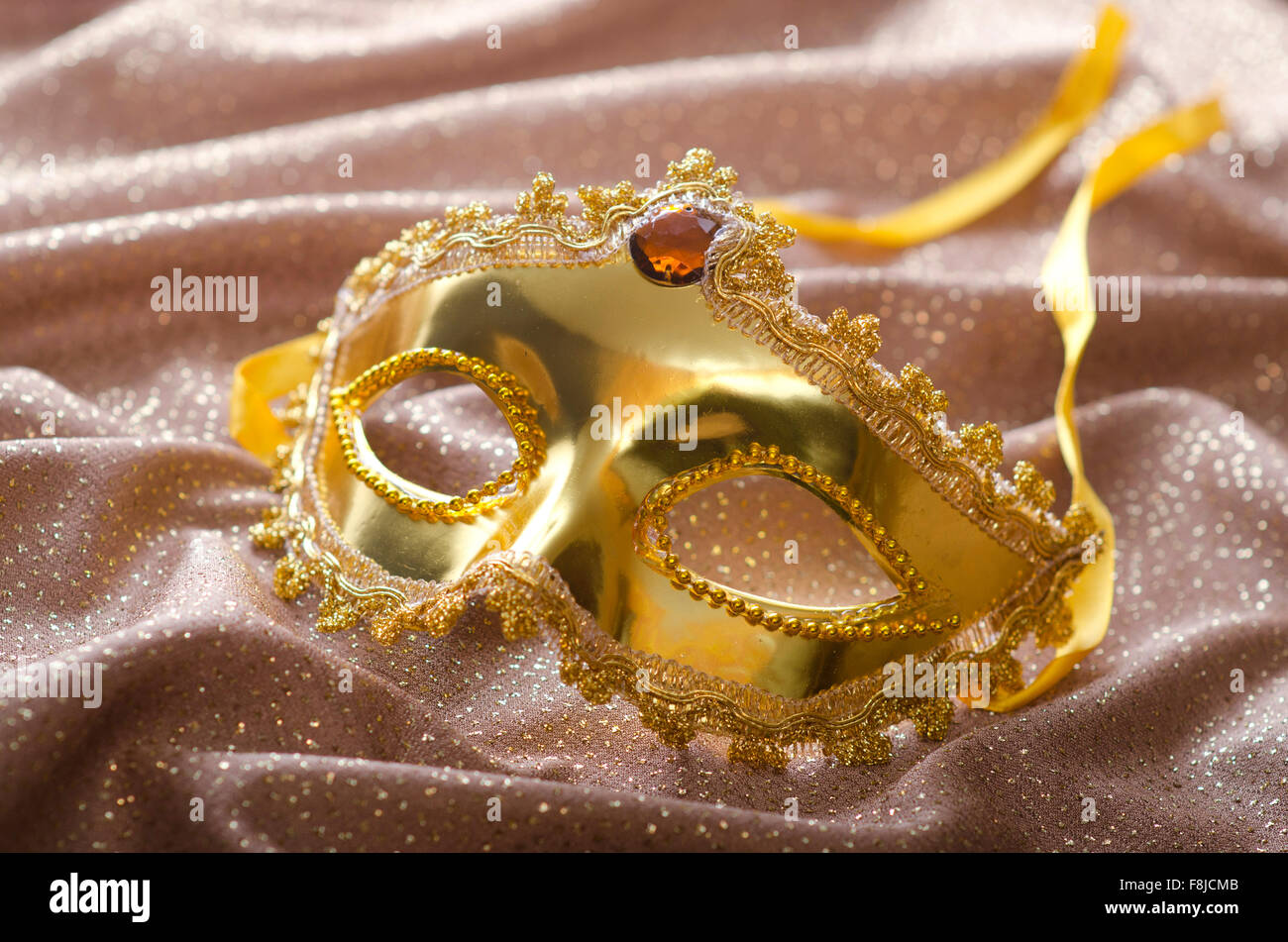 Maschera d'oro su sfondo satinato Foto Stock