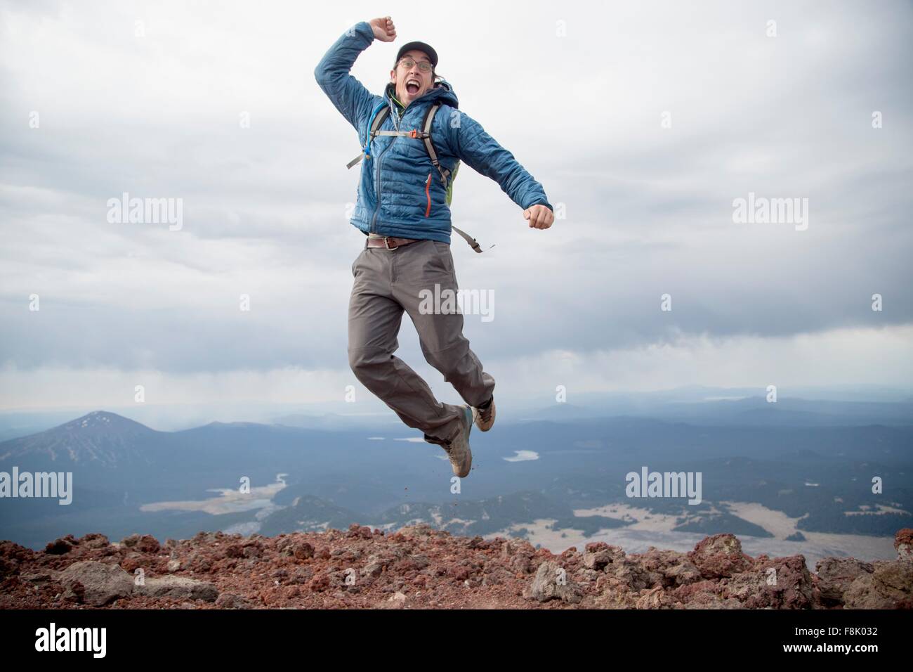 Giovane uomo salti di gioia al vertice del Sud Suor vulcano, piegare, Oregon, Stati Uniti d'America Foto Stock