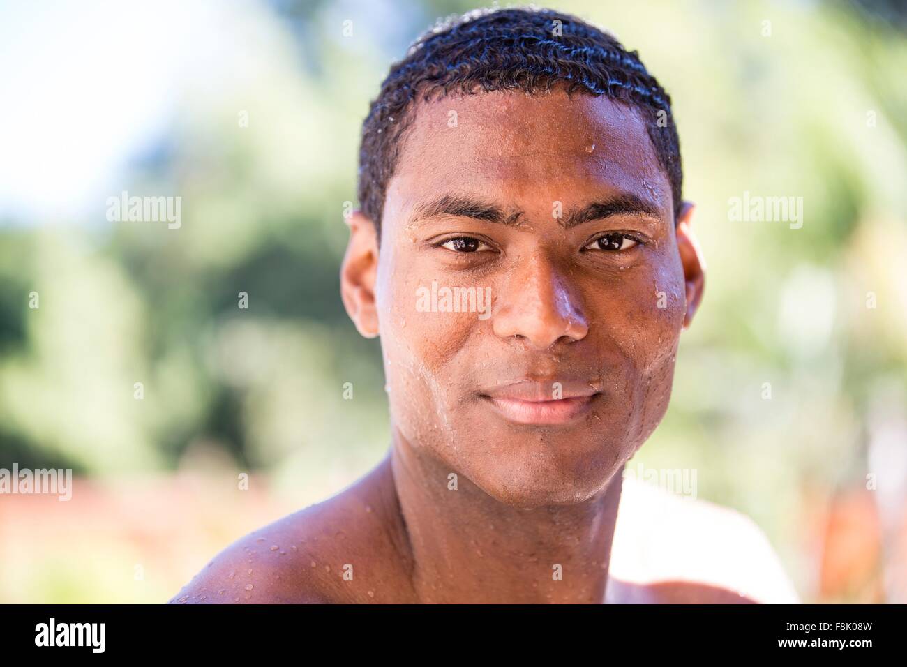 Testa e la spalla ritratto di capelli bagnati metà uomo adulto guardando sorridente della fotocamera Foto Stock