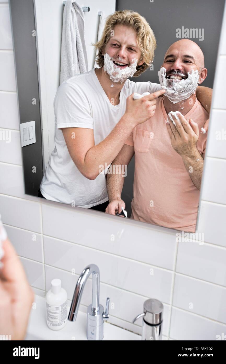 Specchio bagno immagine della coppia maschio avendo divertimento la rasatura Foto Stock