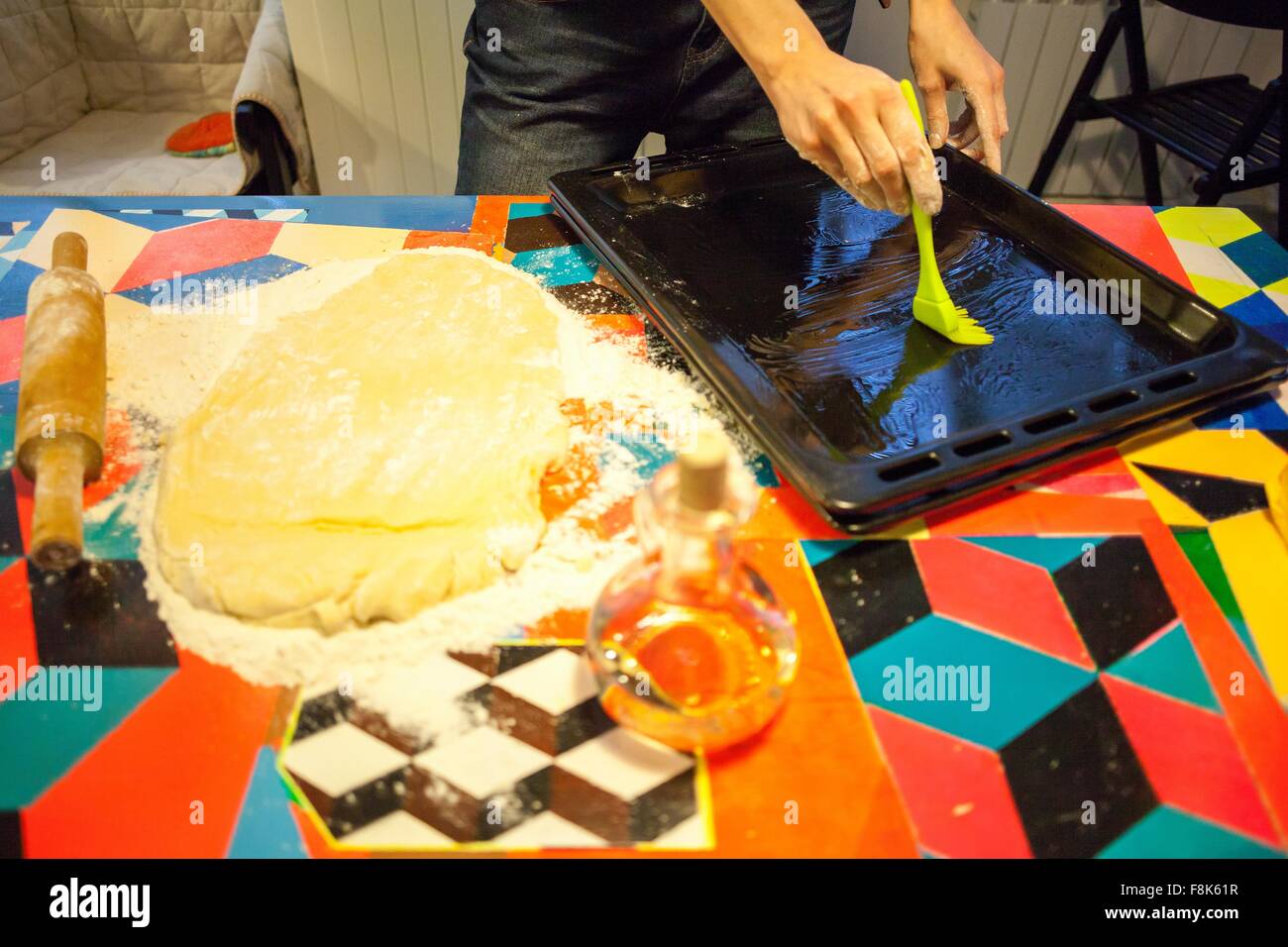 Womans mani oliatura teglia sul tavolo da cucina Foto Stock Womans mani oliatura teglia sul tavolo da cucina Foto Stock