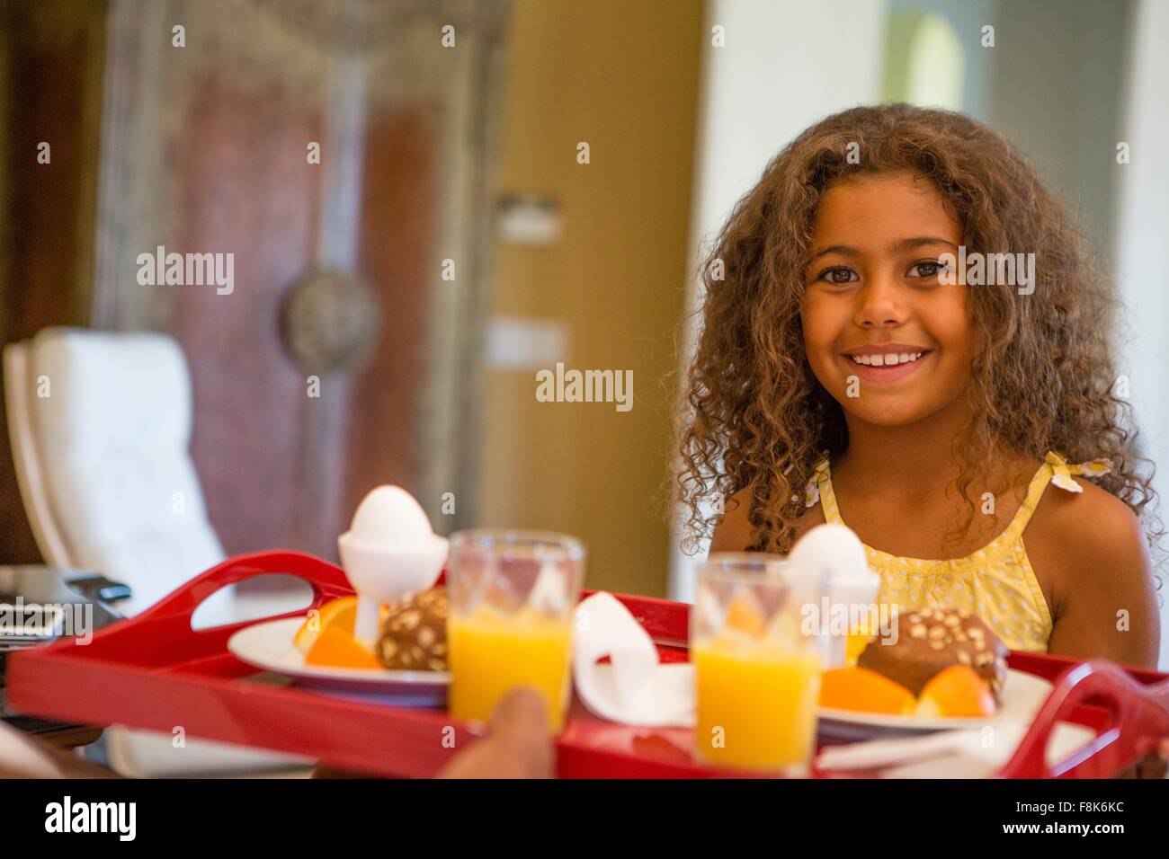 Ragazza giovane con vassoio colazione guardando sorridente della fotocamera Foto Stock