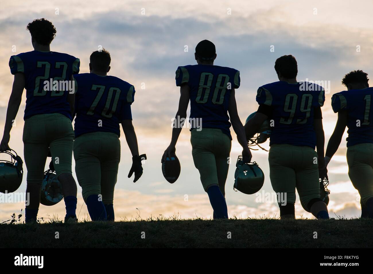 Gruppo di giovani american football giocatori a piedi, vista posteriore Foto Stock