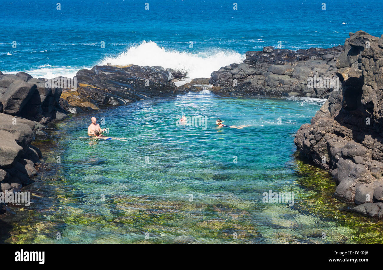I turisti lo snorkeling e il nuoto nel Queens marea bagno piscina vicino a Princeville, Kauai, Hawaii Foto Stock