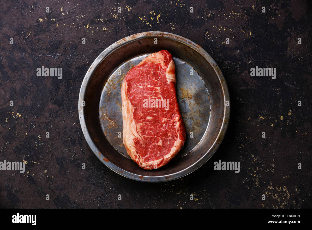 Materie carni fresche bistecca di controfiletto su Lastra metallica su sfondo nero Foto Stock
