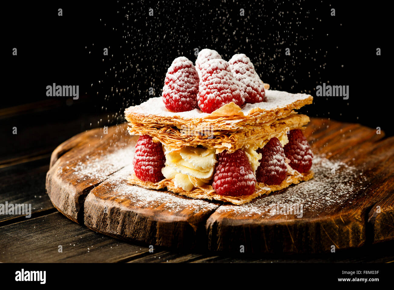 Millefoglie dessert con lampone su sfondo nero Foto Stock