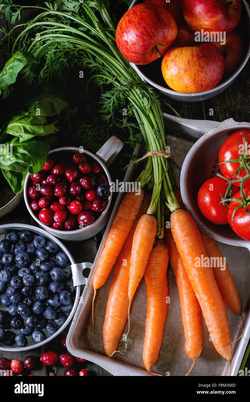 Assortimento di frutta fresca, verdure e frutti di bosco. Mazzetto di carote, spinaci, i pomodori e le mele rosse, mirtilli e cranberr Foto Stock