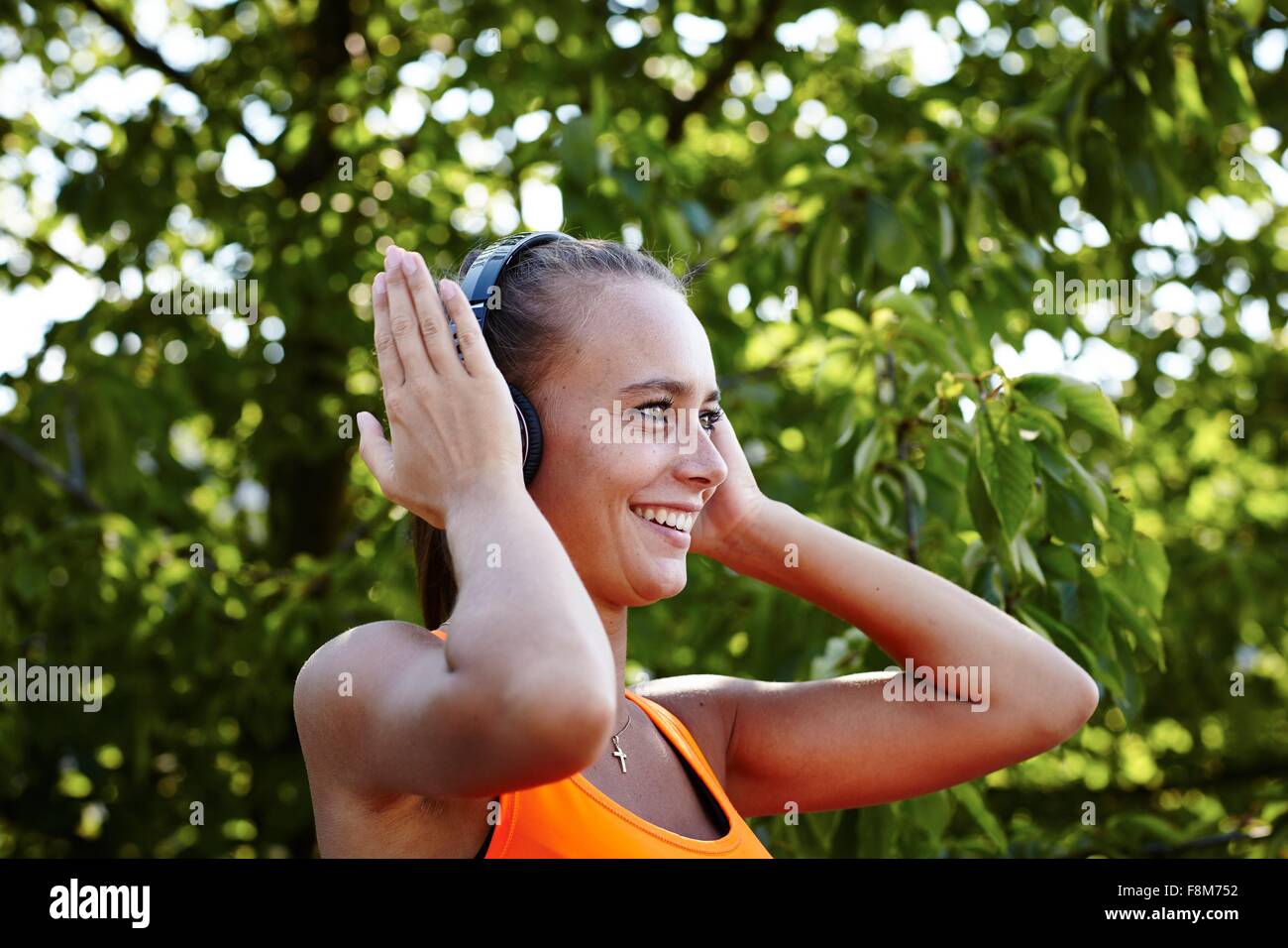 Giovani femmine runner cuffie di regolazione Foto Stock