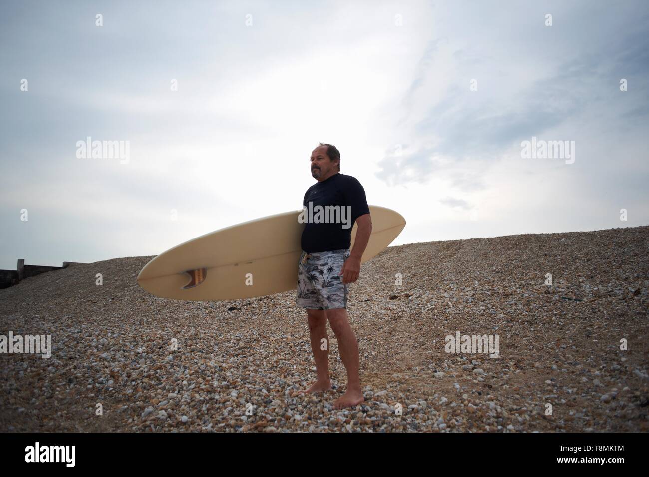 Il surfer che trasportano le tavole da surf in spiaggia Foto Stock