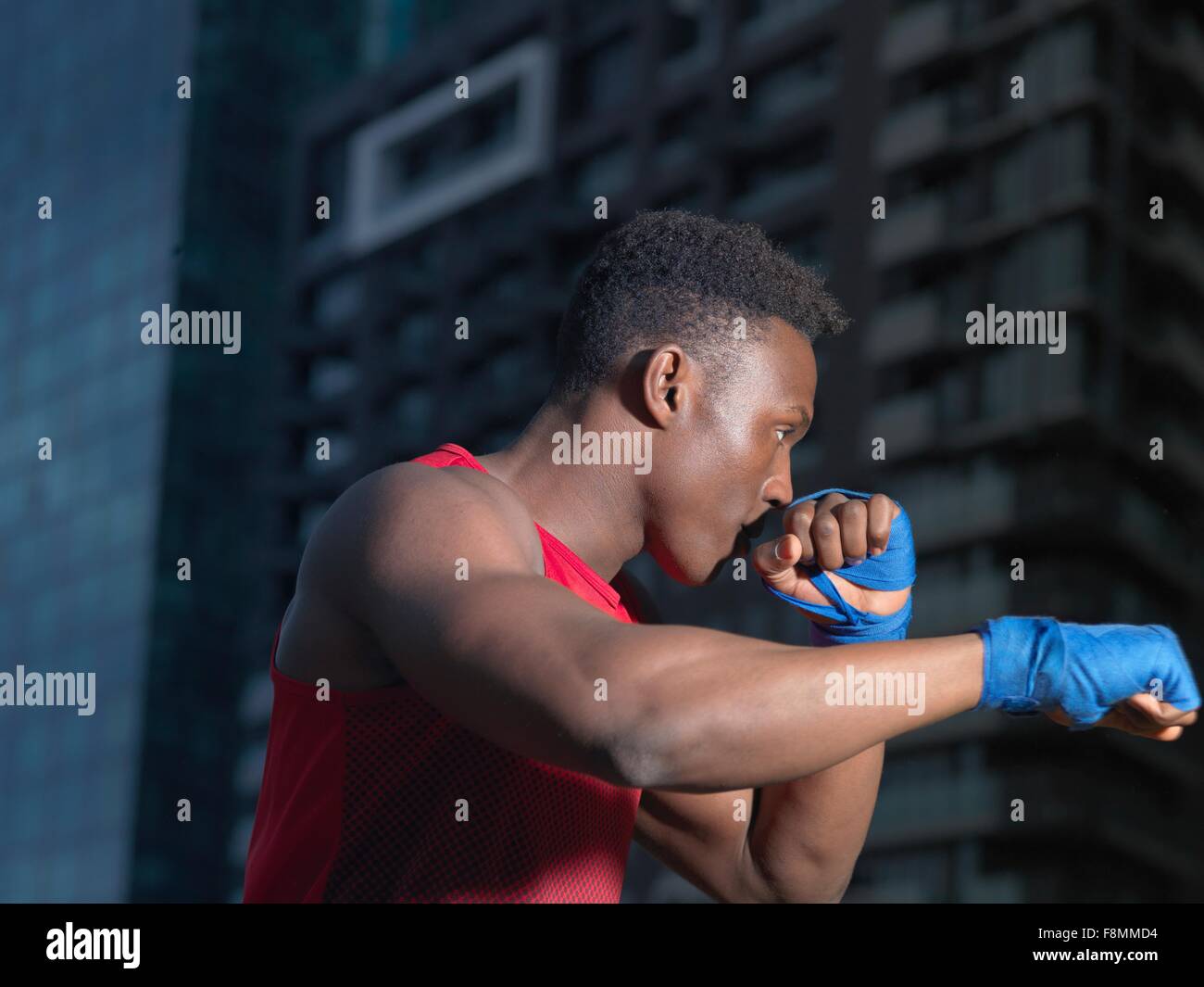 Ritratto di boxer gettando il punzone, edificio in background Foto Stock