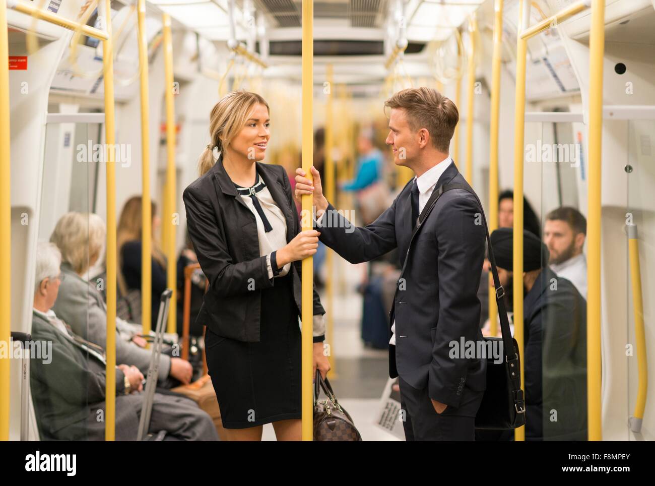 Imprenditore e imprenditrice parlando nel tubo, la metropolitana di Londra, Regno Unito Foto Stock