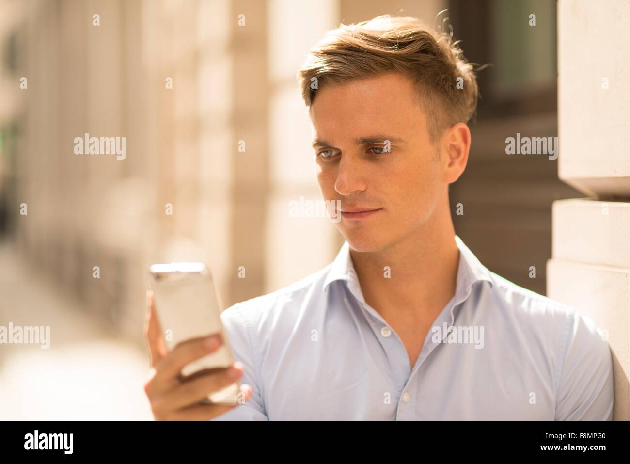 L'uomo texting in strada, vicino fino Foto Stock