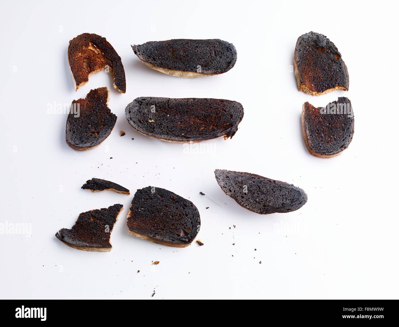 Fette di pane carbonizzato davanti a uno sfondo bianco Foto Stock