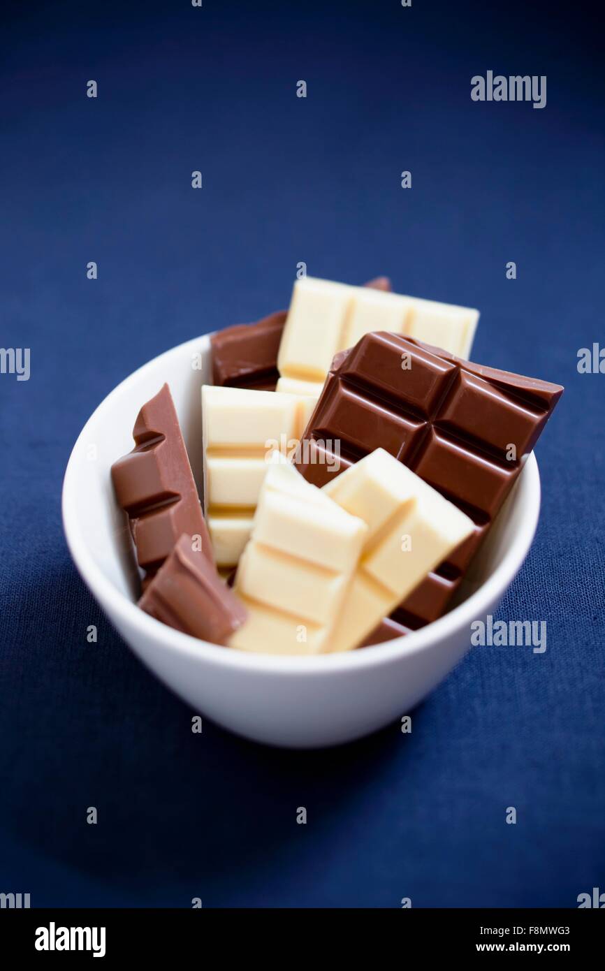 Blocchi di bianco e il cioccolato fondente in una ciotola Foto Stock