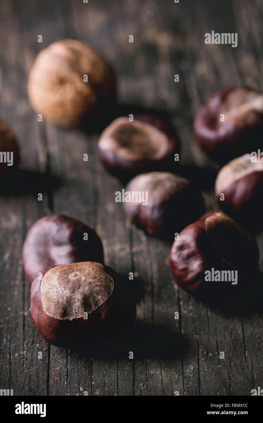 Cumulo di crudo castagne commestibili su un vecchio tavolo di legno. Foto Stock
