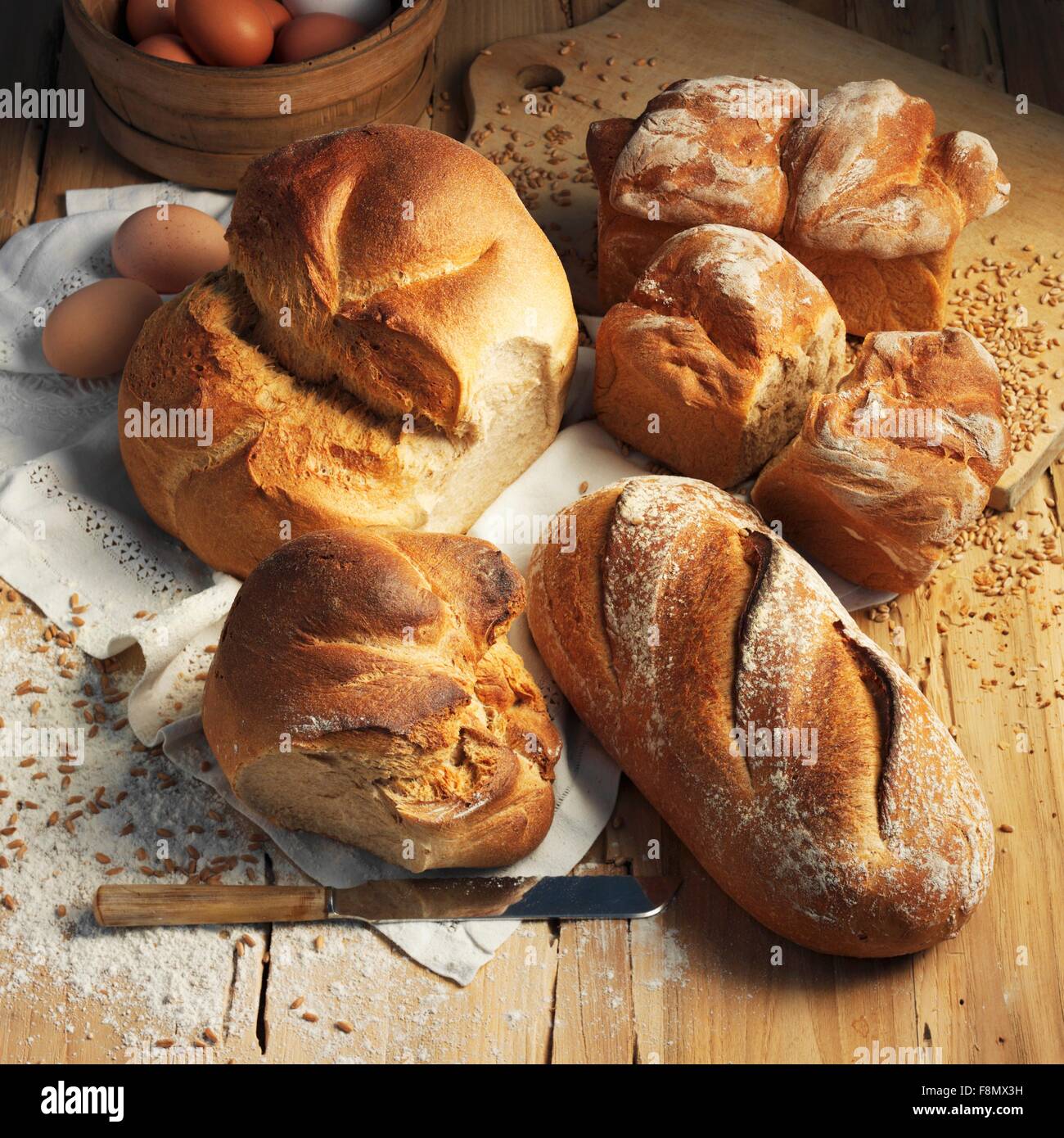 Un assortimento di tipi di pane su una superficie in legno Foto Stock