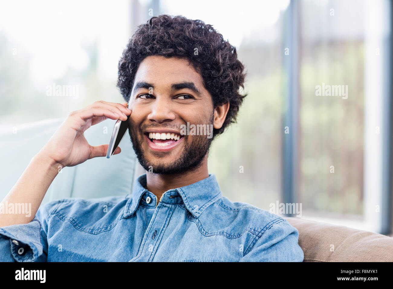 Bel uomo sorridente su chiamata telefonica Foto Stock