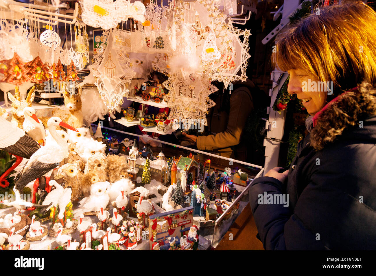 Una donna shopping per le decorazioni di Natale in una fase di stallo, Strasbourg Christmas market, Alsace Francia Europa Foto Stock