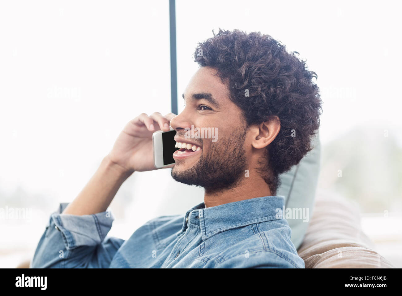 Bel uomo sorridente su chiamata telefonica Foto Stock