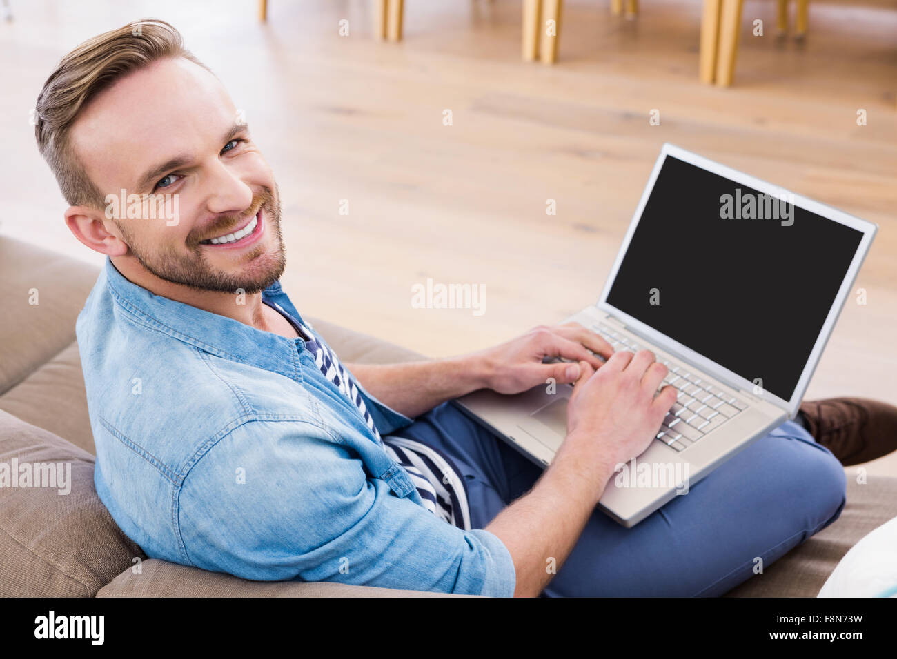 Uomo informale usando il suo computer portatile Foto Stock
