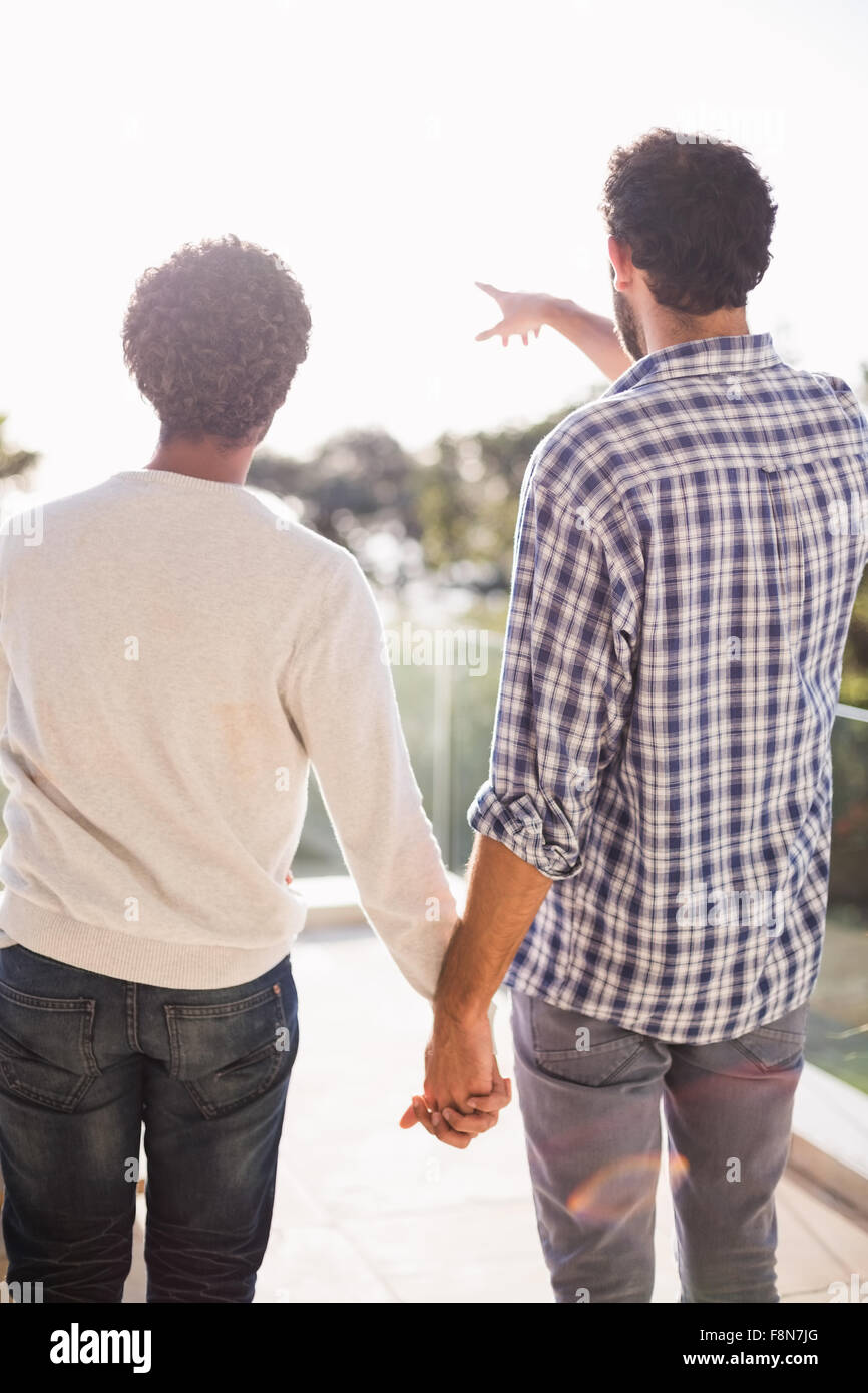 Felice coppia gay tenendo le mani insieme Foto Stock