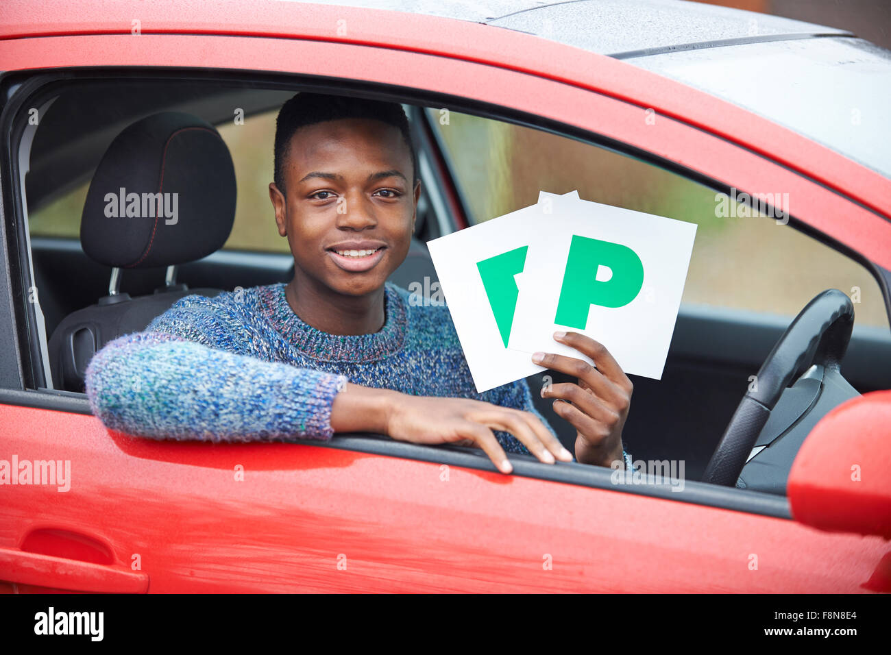 Ragazzo adolescente recentemente superato una prova di guida di contenimento delle piastre P Foto Stock