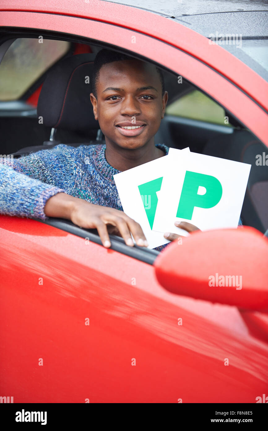 Ragazzo adolescente recentemente superato una prova di guida di contenimento delle piastre P Foto Stock