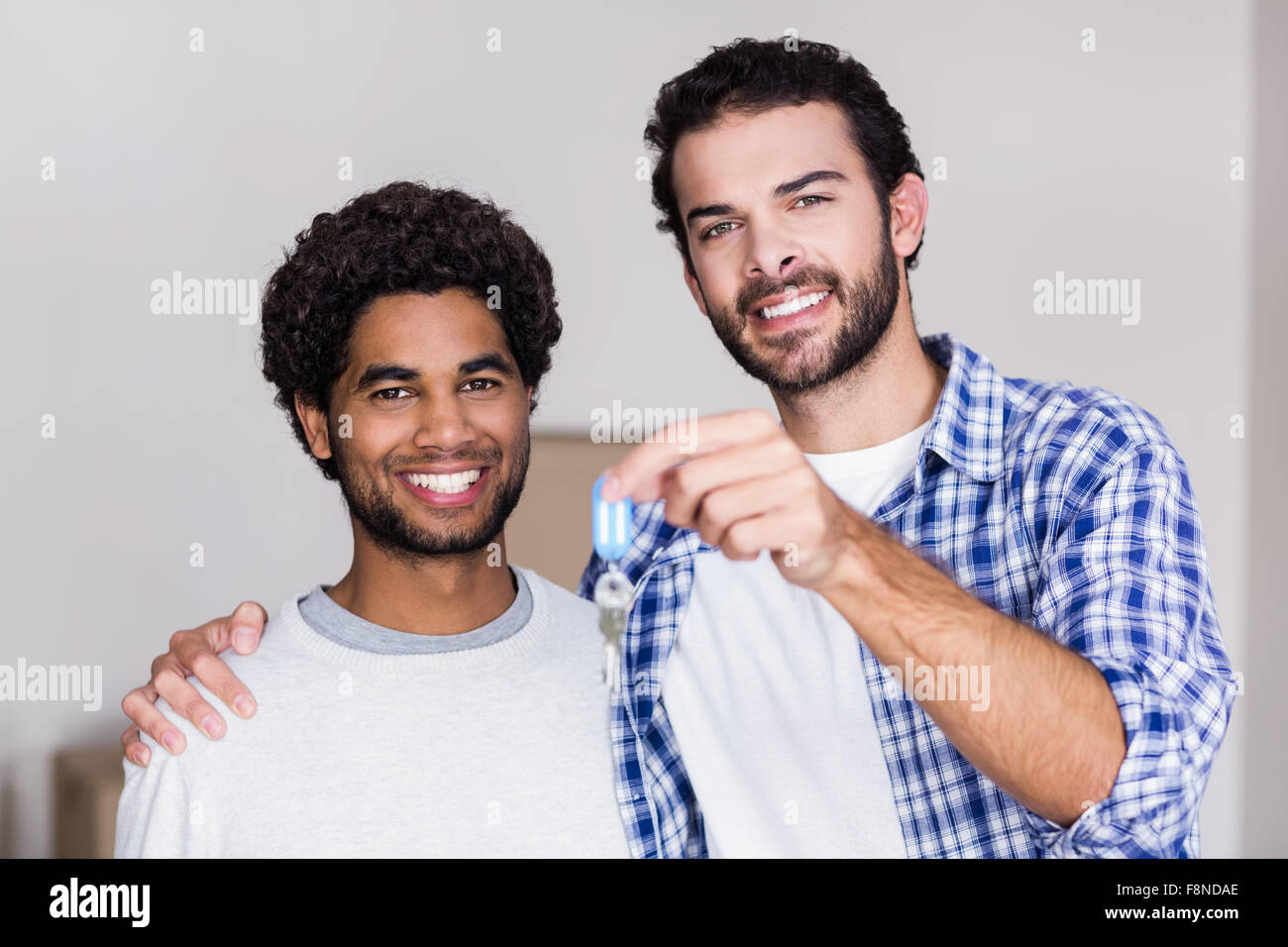 Felice coppia gay azienda nuove chiavi di casa Foto Stock