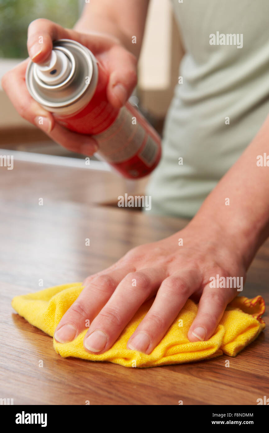 Donna di lucidatura della superficie in legno con Duster Foto Stock