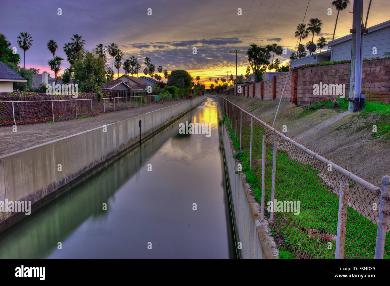 Barranca acqua fluisce nel canale tra le case al mare Foto Stock