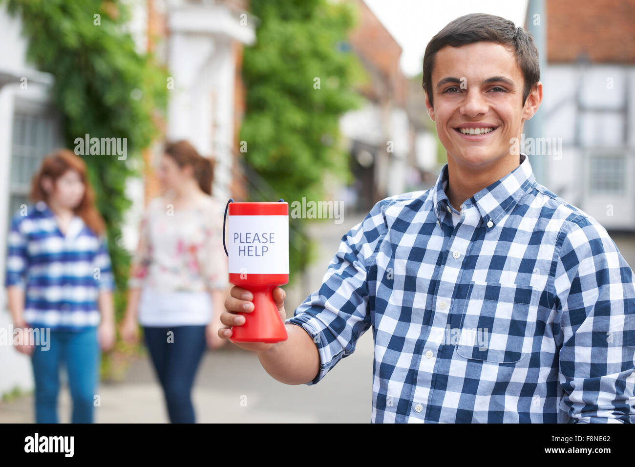 Ragazzo adolescente per raccogliere per la carità in strada Foto Stock