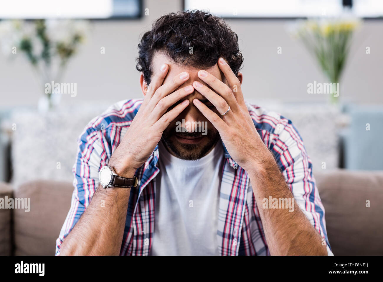 Preoccupato uomo con le mani sul suo volto Foto Stock