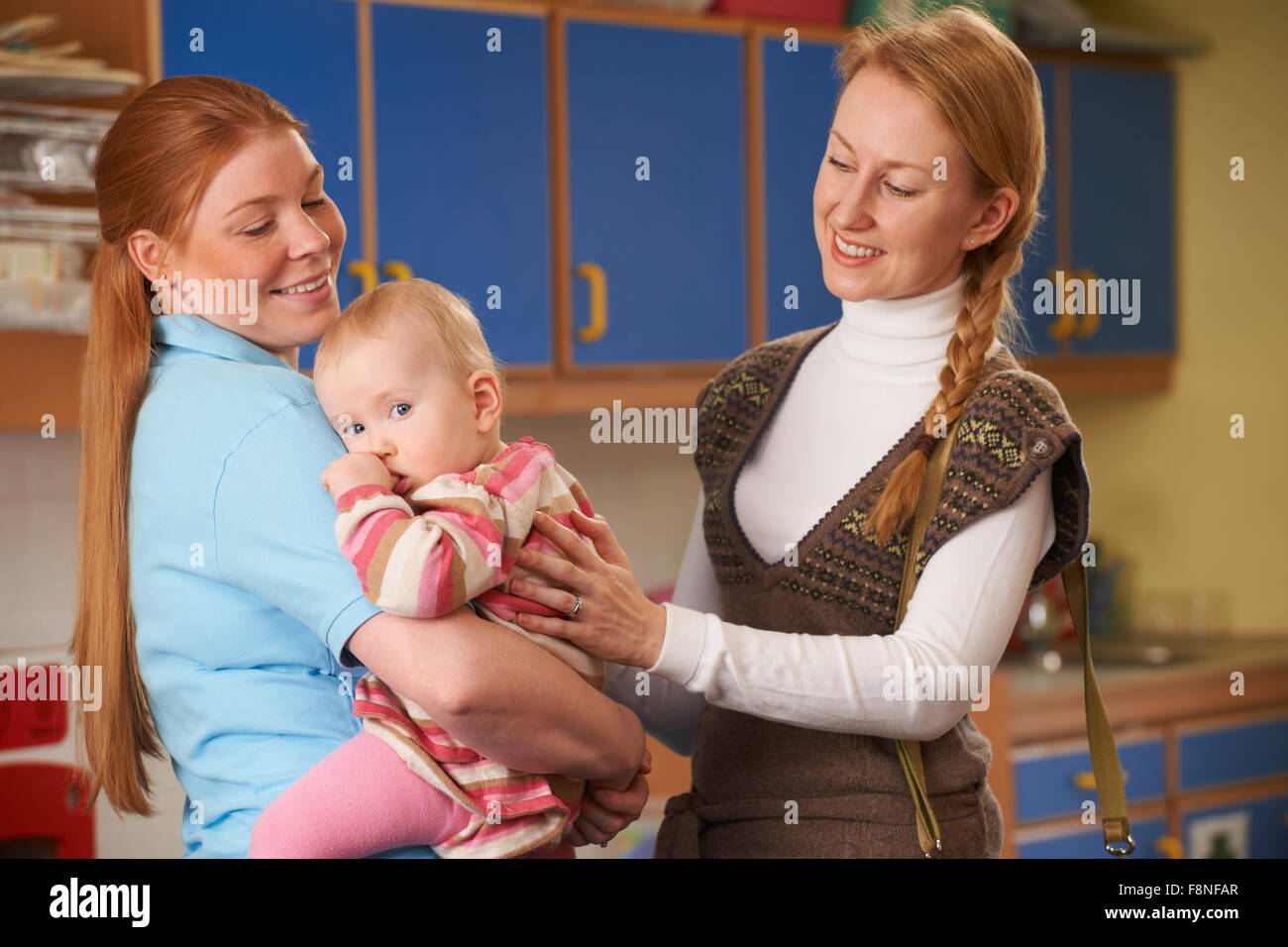 Madre di lavoro la caduta di Baby al vivaio Foto Stock