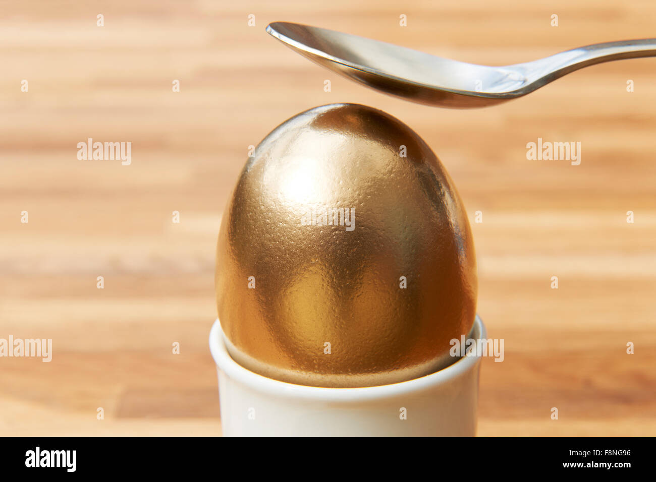 Cracking cucchiaio Golden Egg Foto Stock