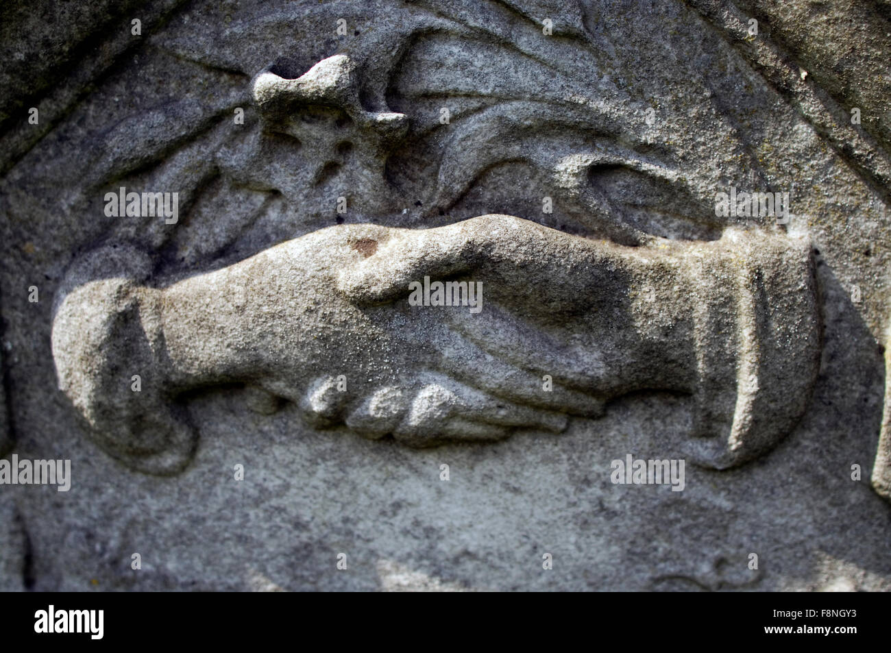 Due mani agitando come parte di una più grande scultura in pietra Foto Stock