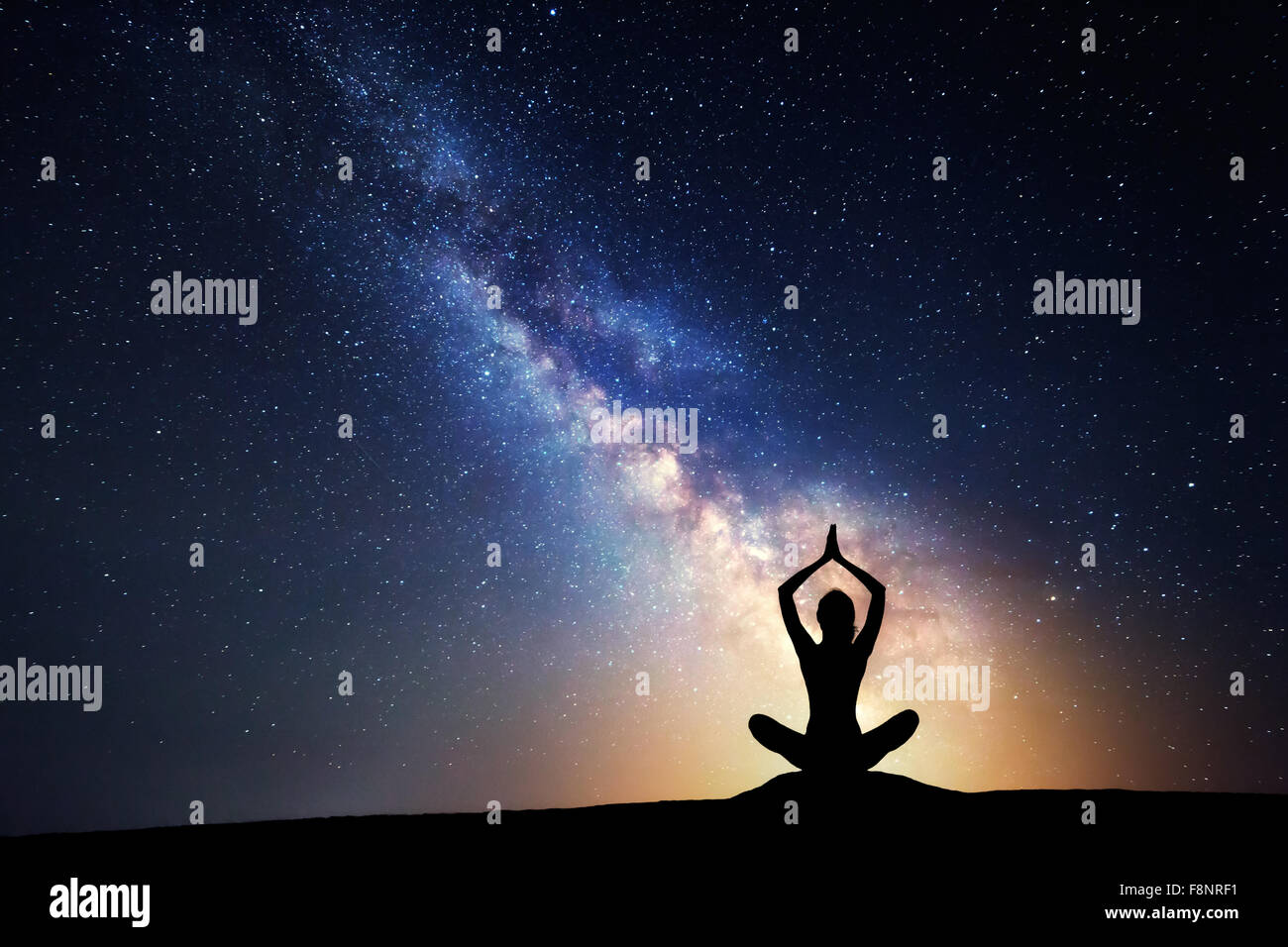 Via Lattea. Cielo notturno con stelle e silhouette di donna pratica dello yoga. Foto Stock