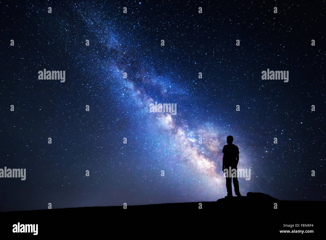 Via Lattea. Cielo notturno con stelle e la silhouette di un uomo con in rilievo le armi Foto Stock