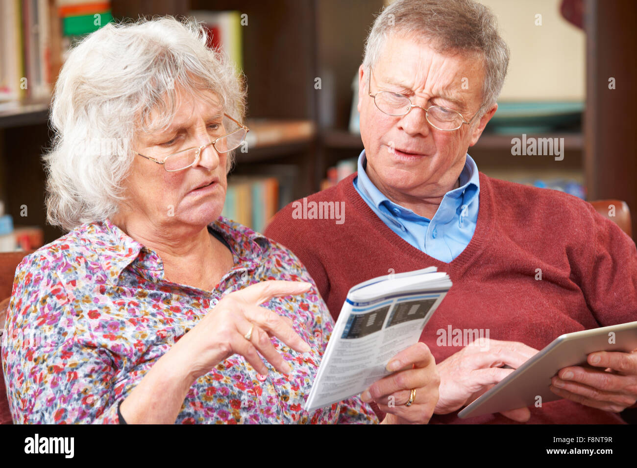 Confuso coppia Senior cercando di far funzionare il telefono cellulare Foto Stock